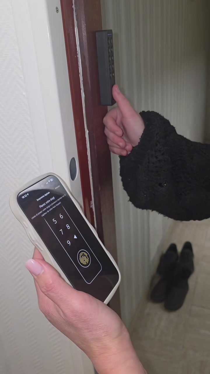 Enregistrement d'une empreinte digitale dans l'appli Nuki, à côté du clavier posé près de la porte